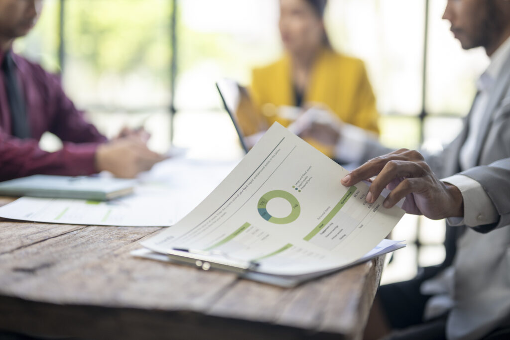 a man is pointing at a pie chart on a table in fro 2025 10 01 01 05 22 utc.jpg